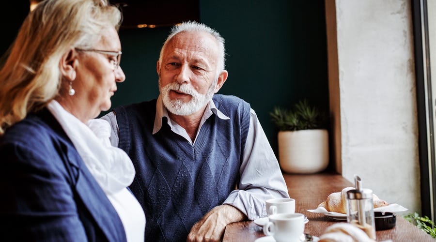 man apologises to a woman in a café