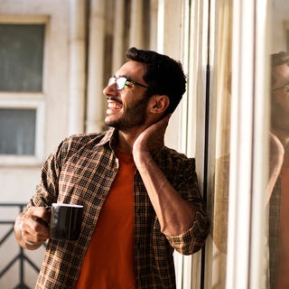 Man drinking coffee on a balcony after his English language class with Berlitz UAE