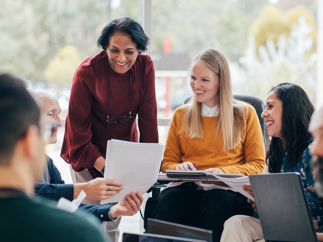 A group of students and their instructor during an in-person language course for adults
