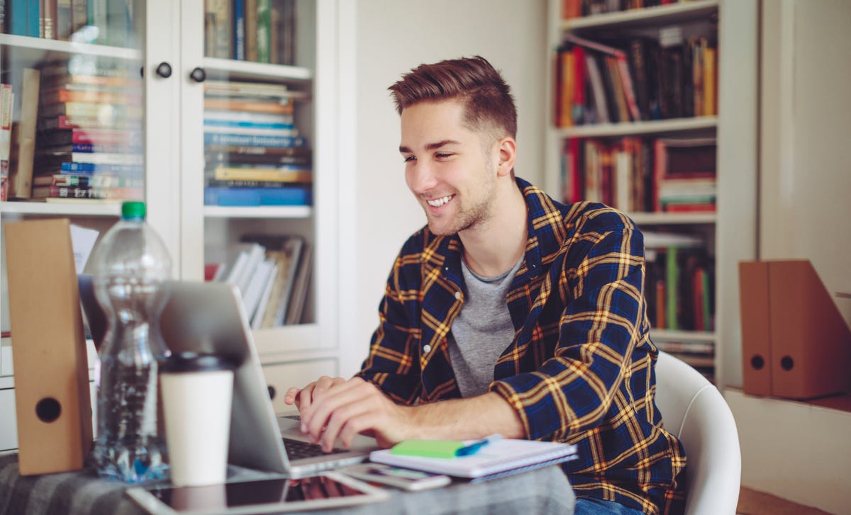 A man attending an online language class on his laptop