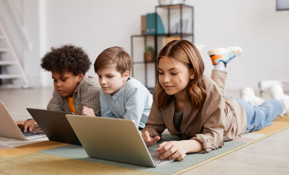 Three children attending an online class on their laptops