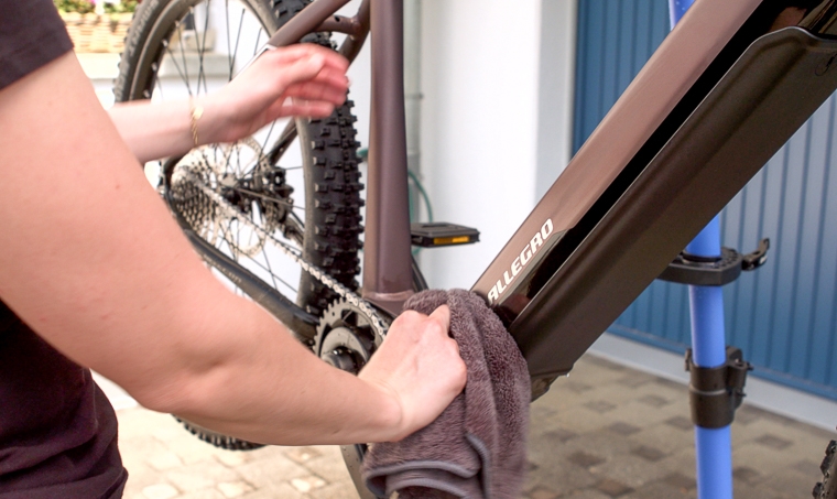 Gina Trocknet den Rahmen des E-Bikes mit einem Mikrofasertuch