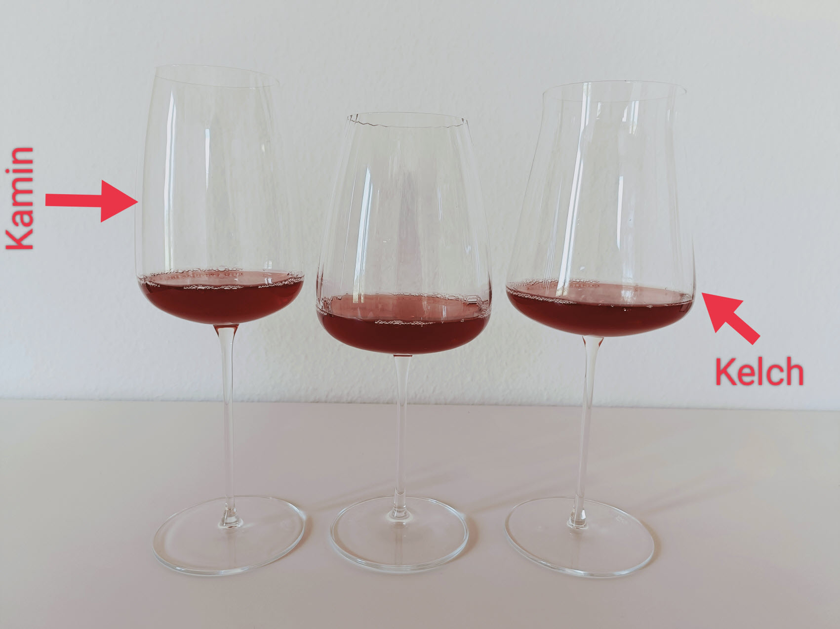 Drei Weingläser gefüllt mit Wein und den Hinweisen auf den Kamin und Kelch.
