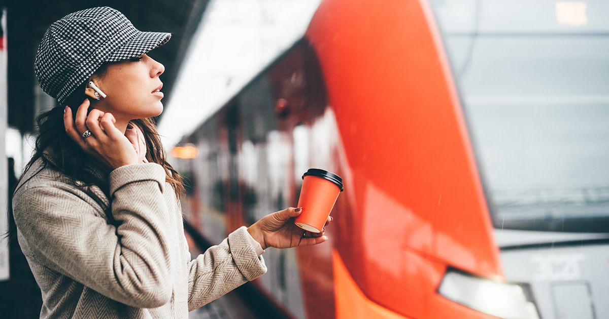 Frau mit Kopfhörern am Bahnhof.jpg