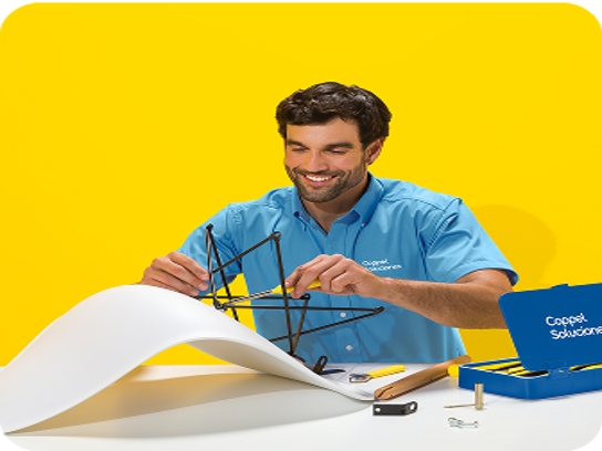 Un solucionador armando una silla sobre una mesa contra un fondo amarillo brillante.
