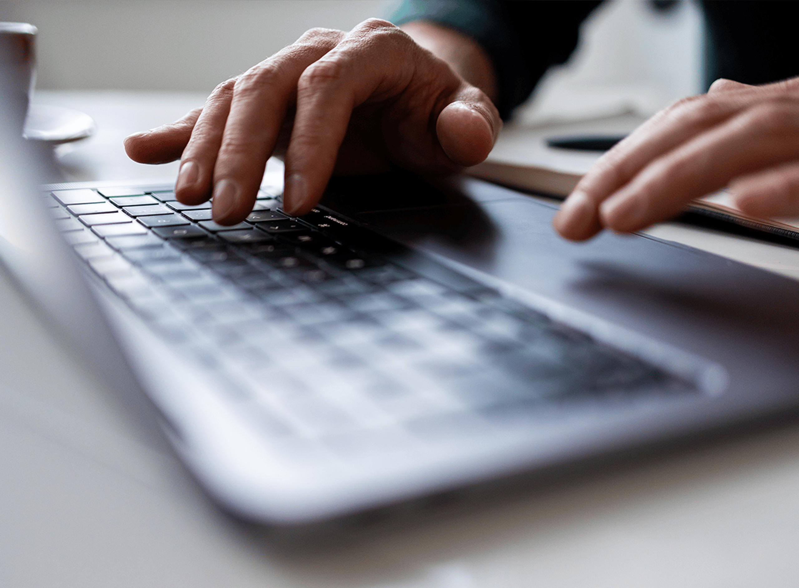 Hands typing on a laptop