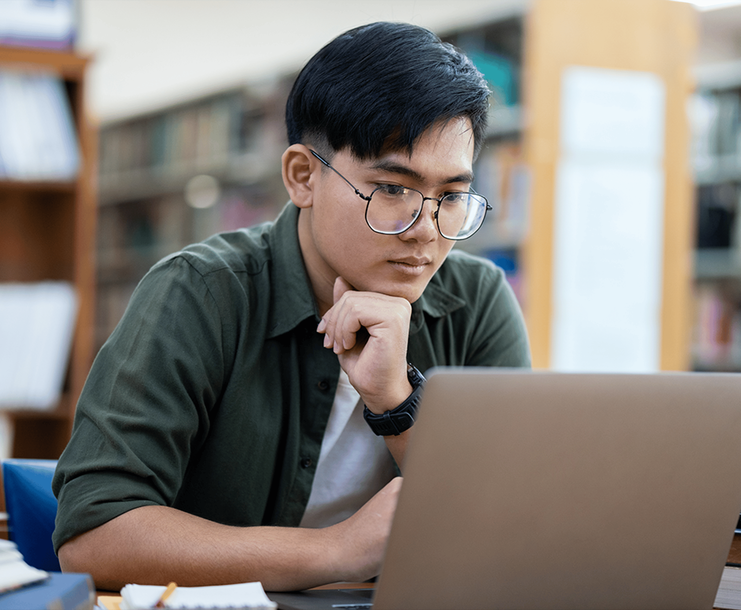 Man in green shirt staring at a laptop