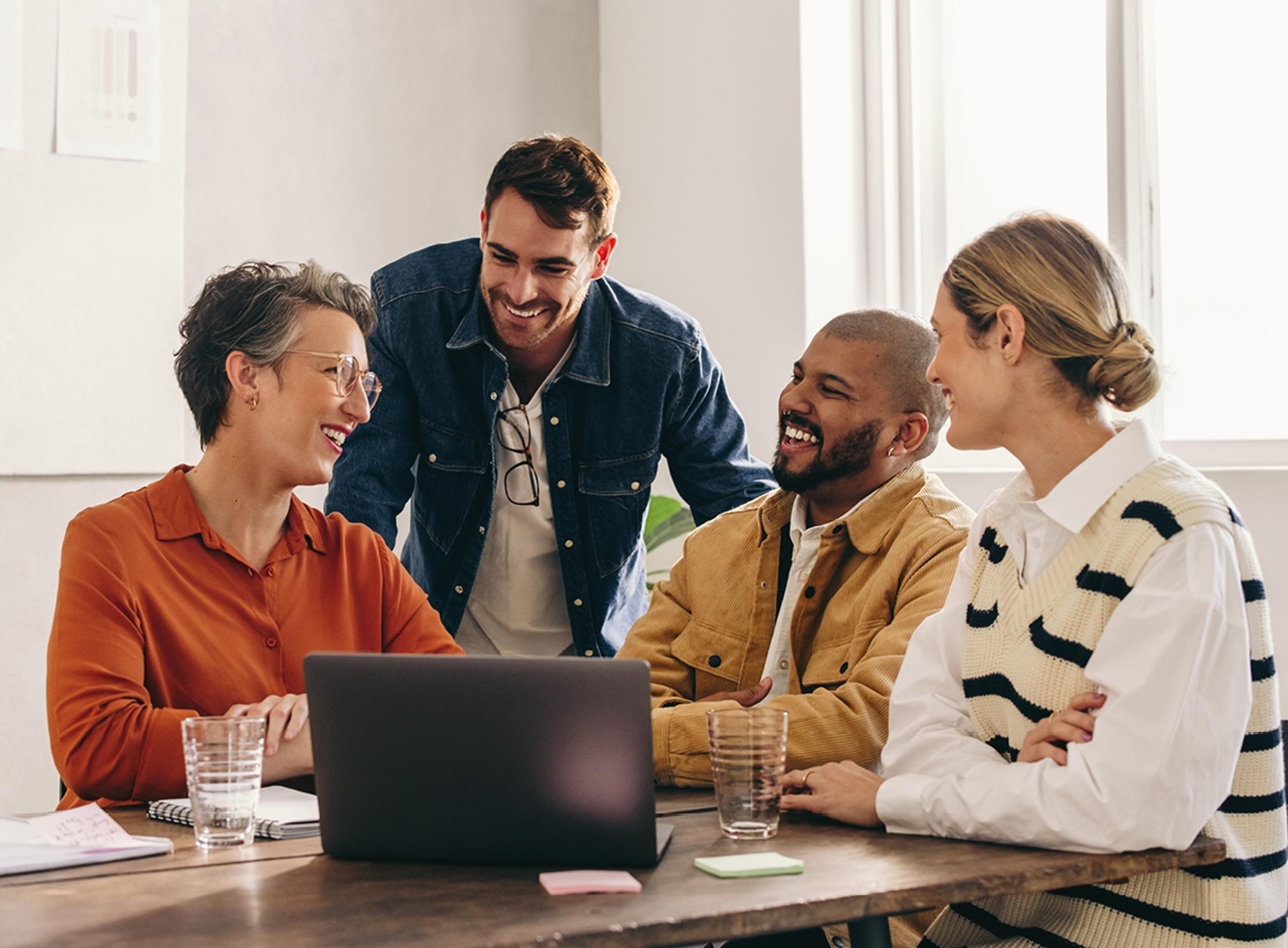 People Laughing While Working on a Laptop