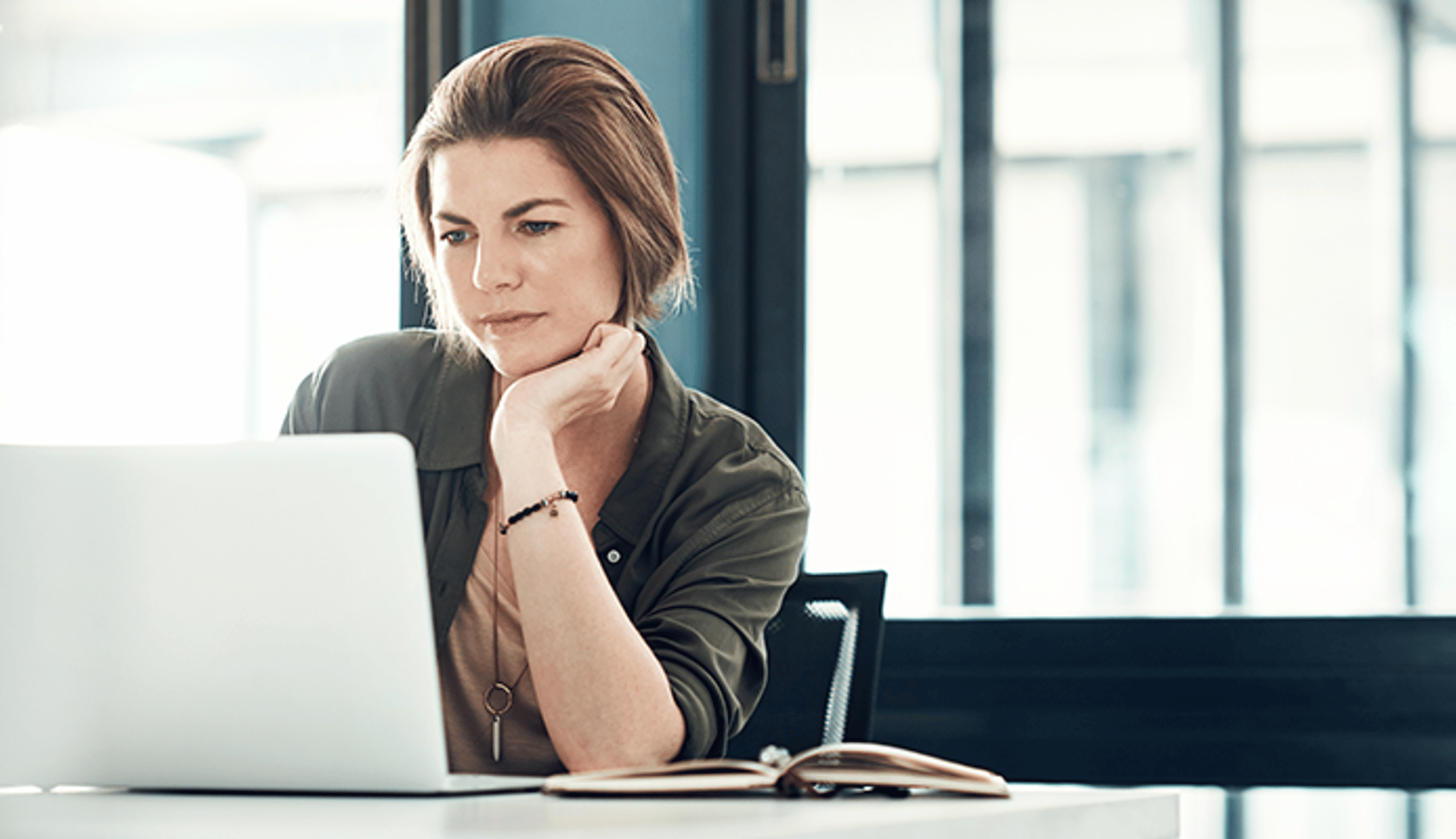 Woman looking at laptop screen in home office