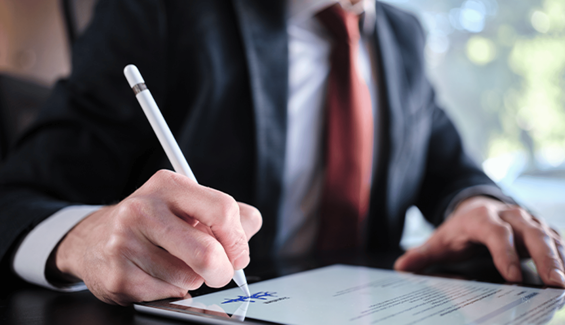 Man writing signature on a document