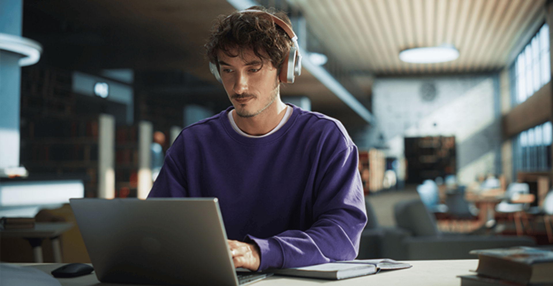 Man working at a laptop making notes