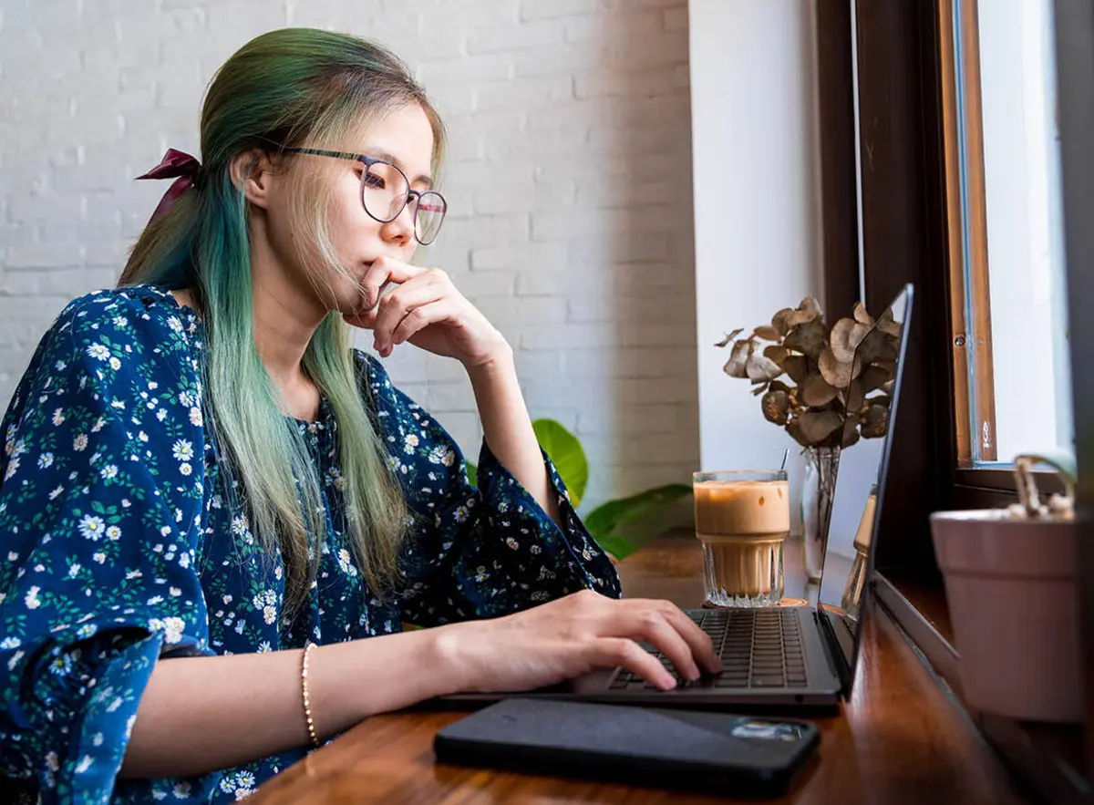 Woman Sitting at Laptop With Coffee