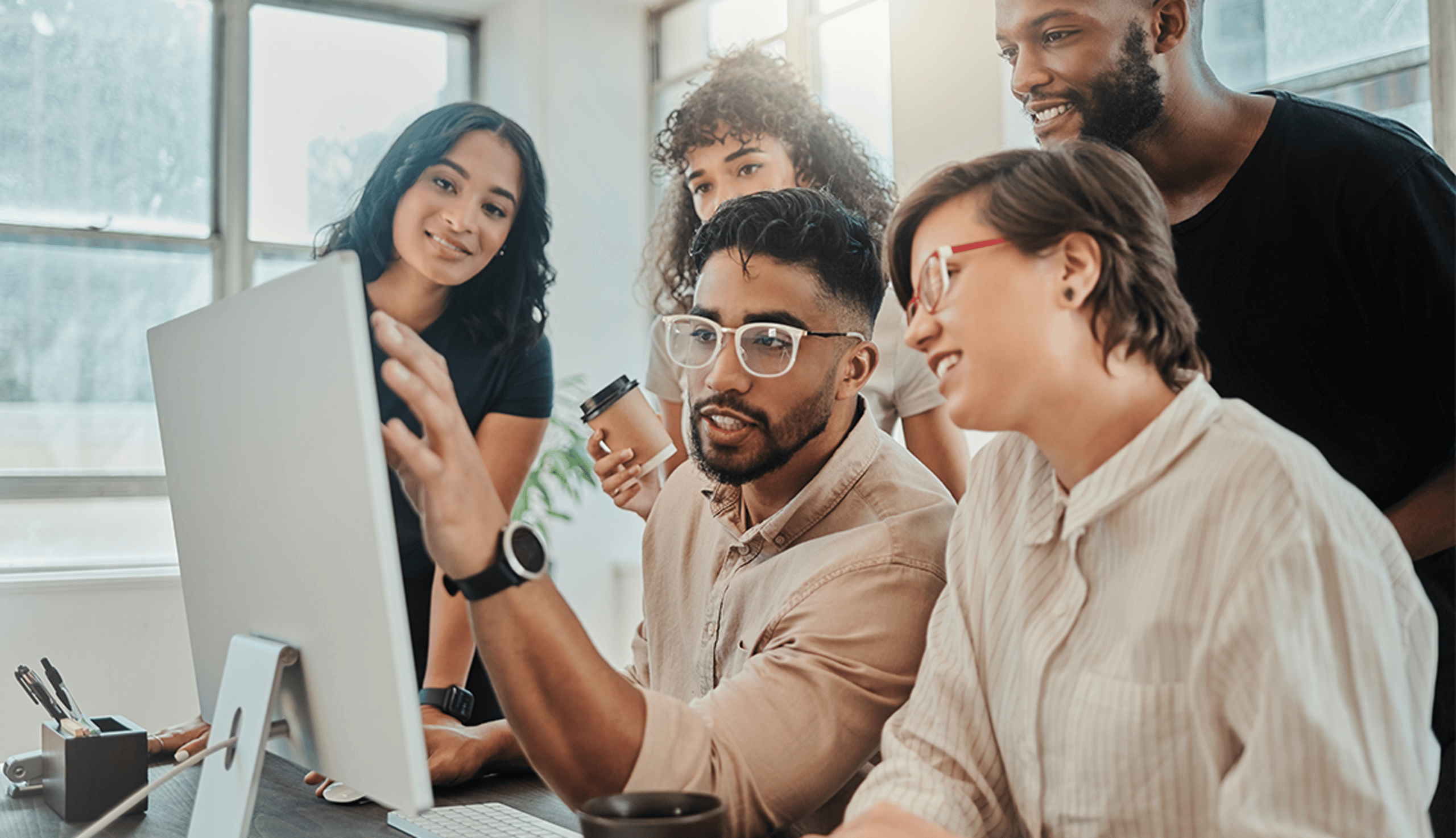 Five People Gathered Together and Looking at a Computer