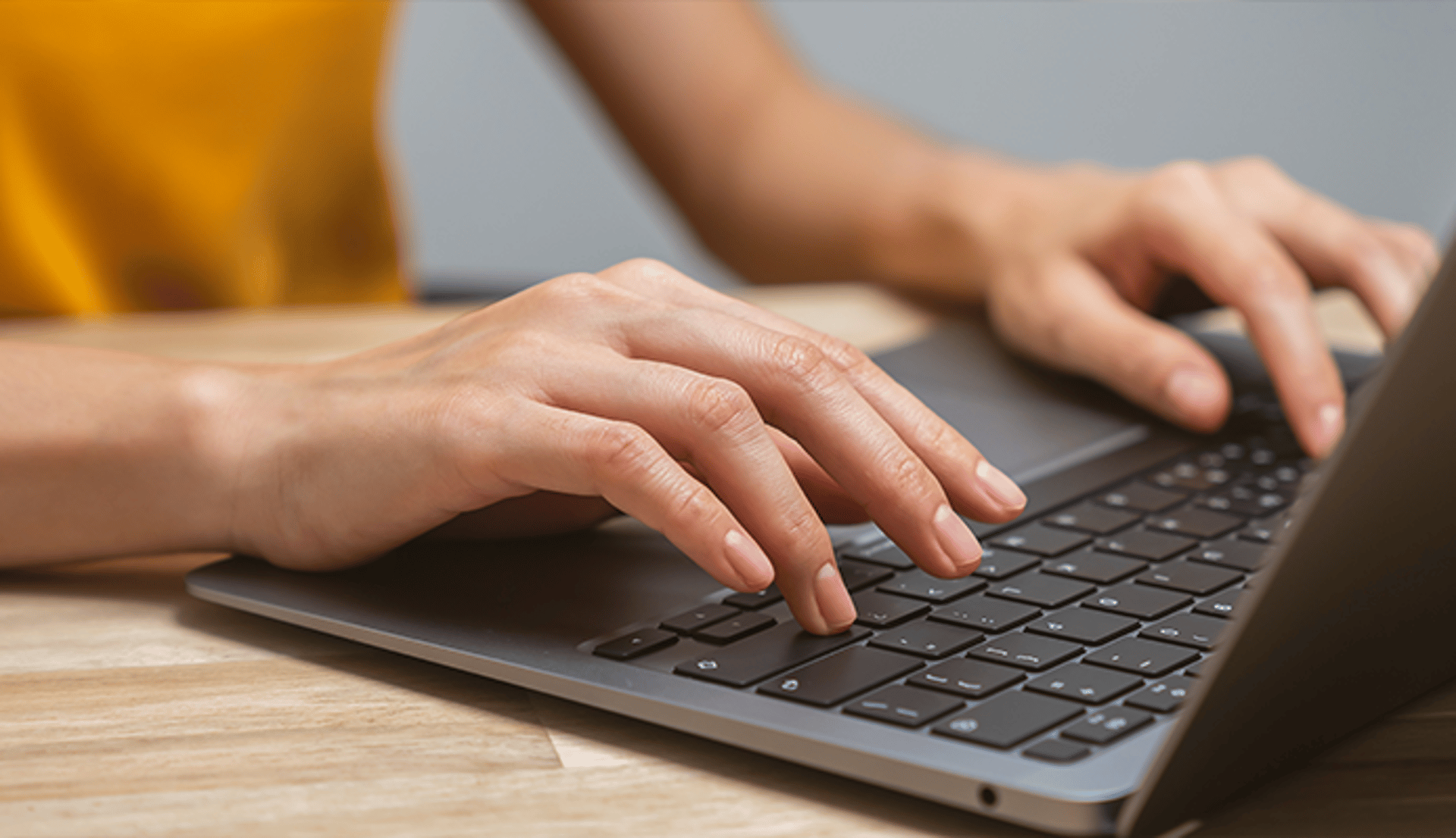 Hands typing on a laptop