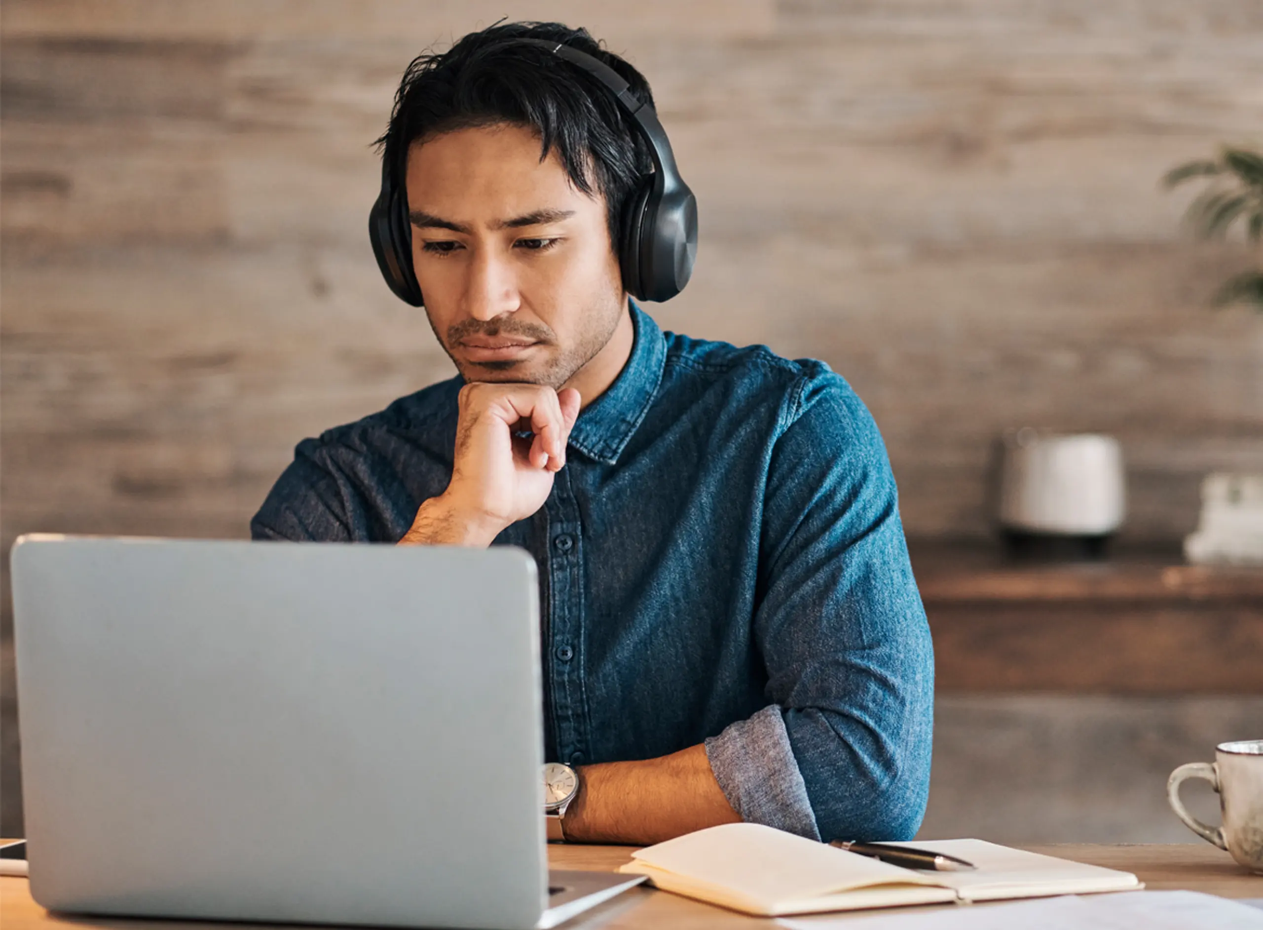 Man Looking at Laptop While Wearing Headphones
