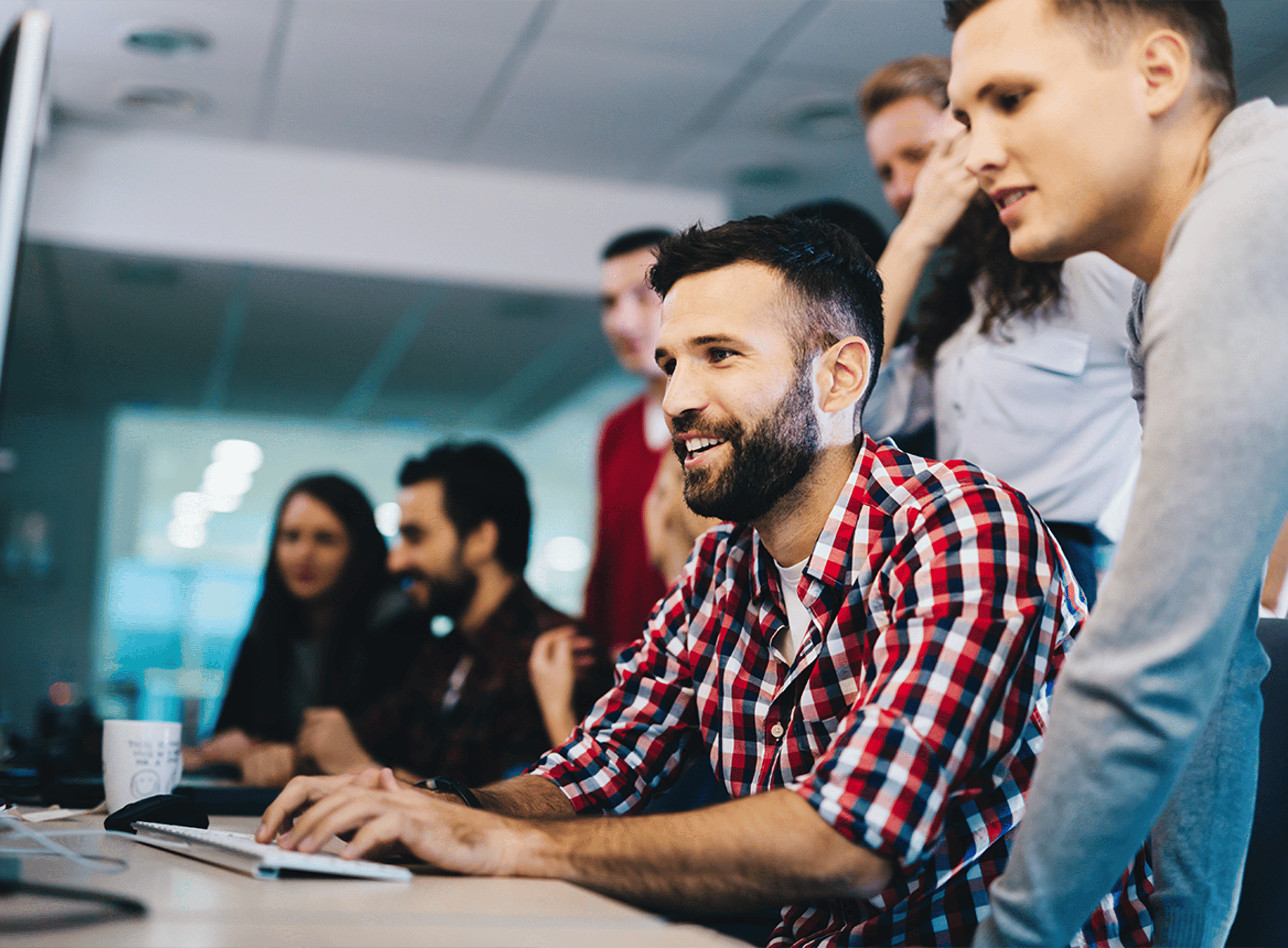 A Group of People Smiling and Looking at a Computer