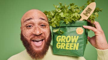 man holding a grown green veg bag