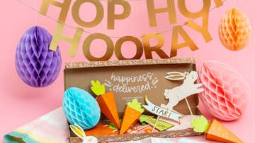 Hop hooray gold letter banner and box of Easter paper decorations