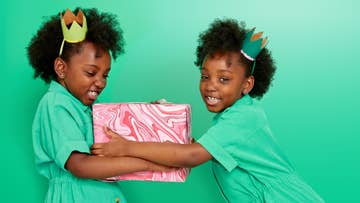 two girls holding a pink gift boxes
