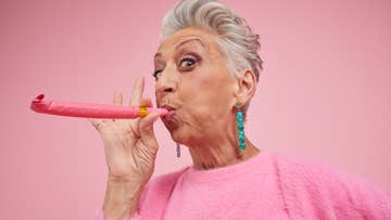 women holding a pink party blower