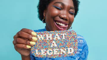 women holding a chocolate bar covered in sprinkles