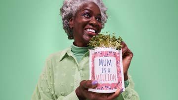 Lady holding plant pot which says 'mum in a million'