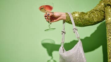 arm holding a bag and wine glass