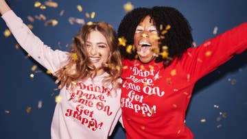 two women wearing Christmas jumpers