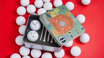small metal tin with 2 golf balls and tees inside