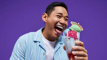 man is blue shirt holding a ice-cream sundae
