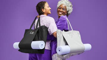 two women holding matching yoga mat bags with initials