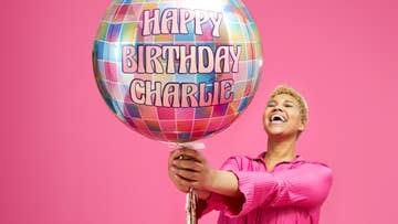 woman holding a balloon personalised with Happy Birthday Charlie