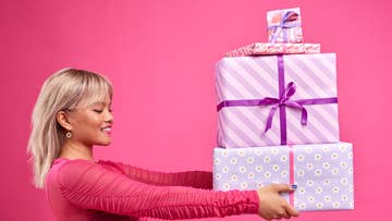 women holding a stack of presents