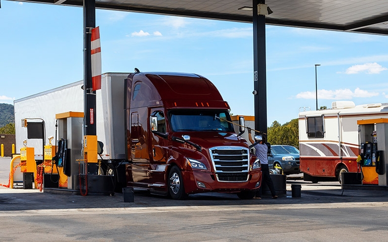 A semi-truck fueling up at the pump.