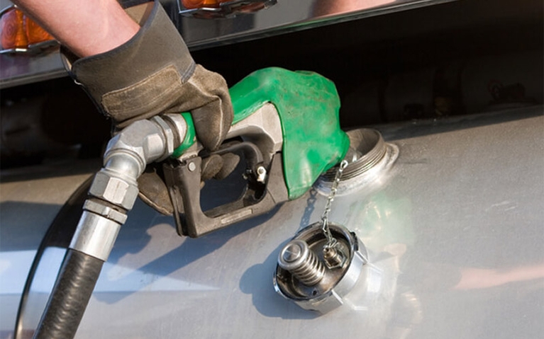 A closeup of a green diesel pump fueling up a vehicle.