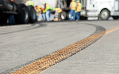 A black tire skid mark that crosses the yellow center line indicates that a driver swerved into the opposite lane.