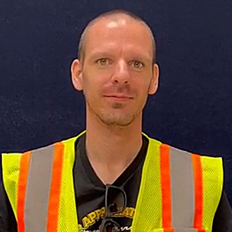 an owner-opeartor wearing a yellow and orange safety vest
