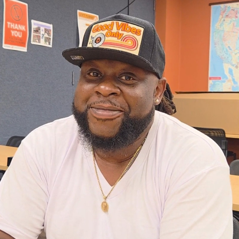 an owner-operator wearing a white t-shirt and a hat