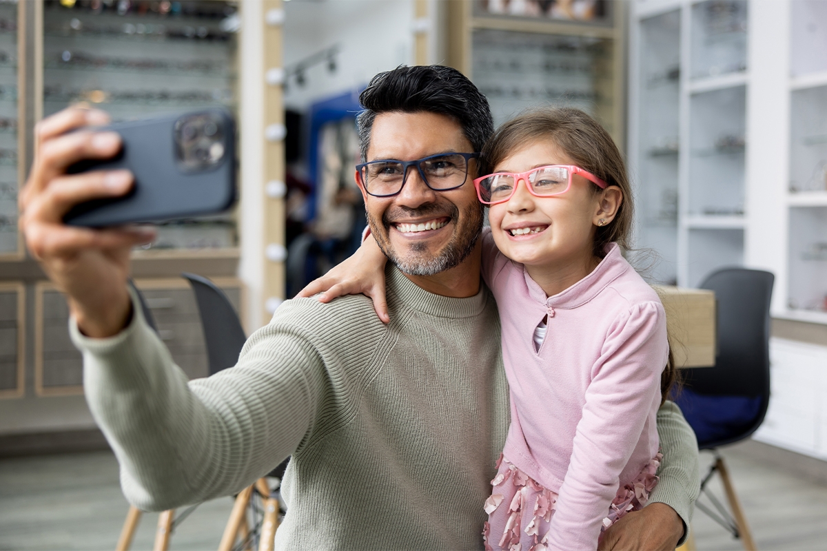 Father and daughter wearing glasses taking a selfie