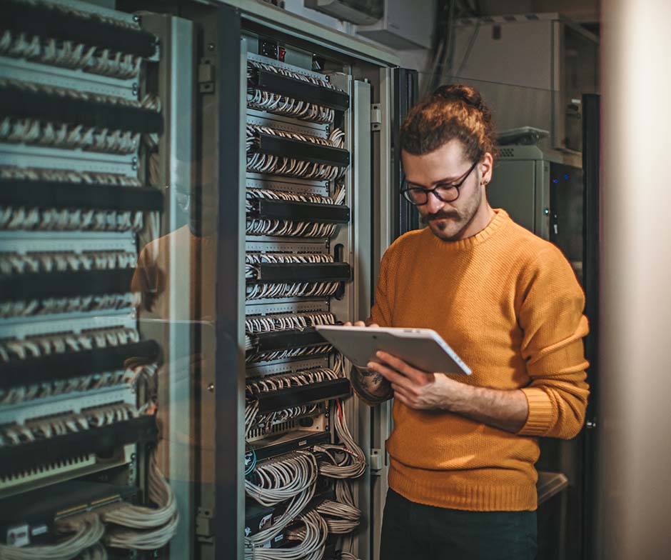 person working with laptop in datacenter