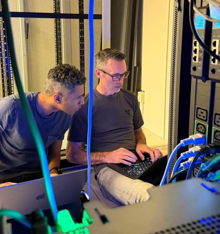 Two colleagues conversing in a data center