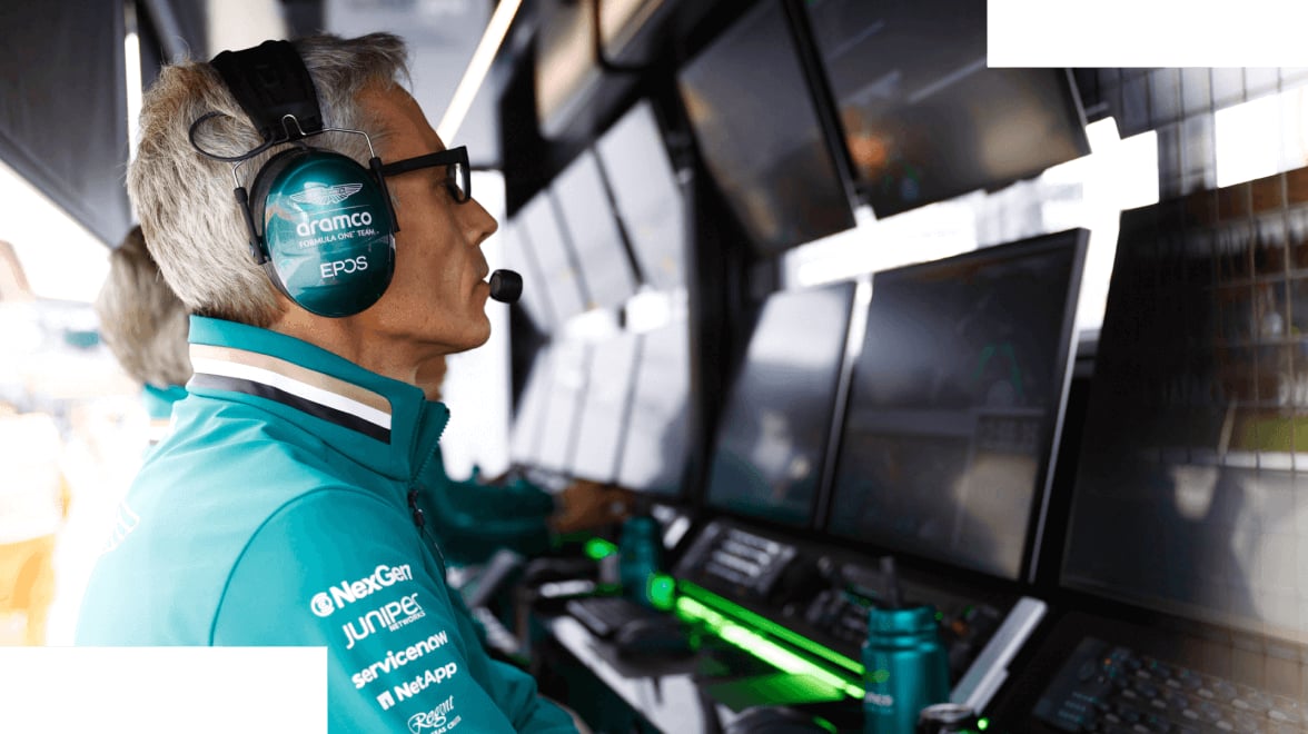 Vista di profilo di un membro dell'equipaggio dei box Aston Martin F1 che guarda gli schermi per valutare le prestazioni.