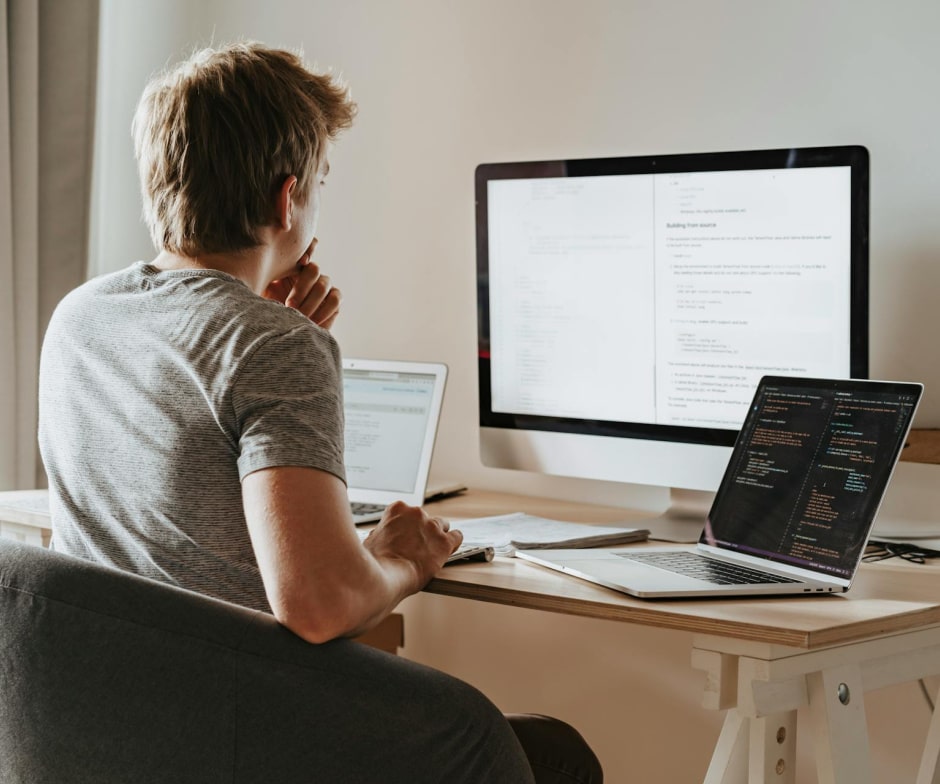 person working on office desk and looking at monitor