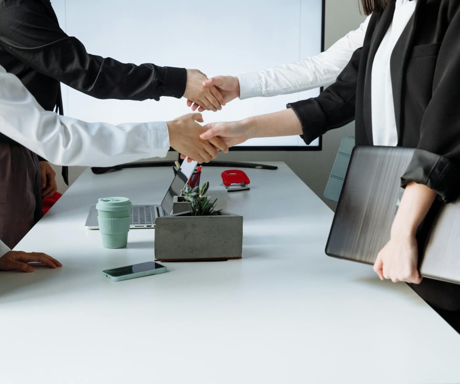professionals shaking hands in conference room