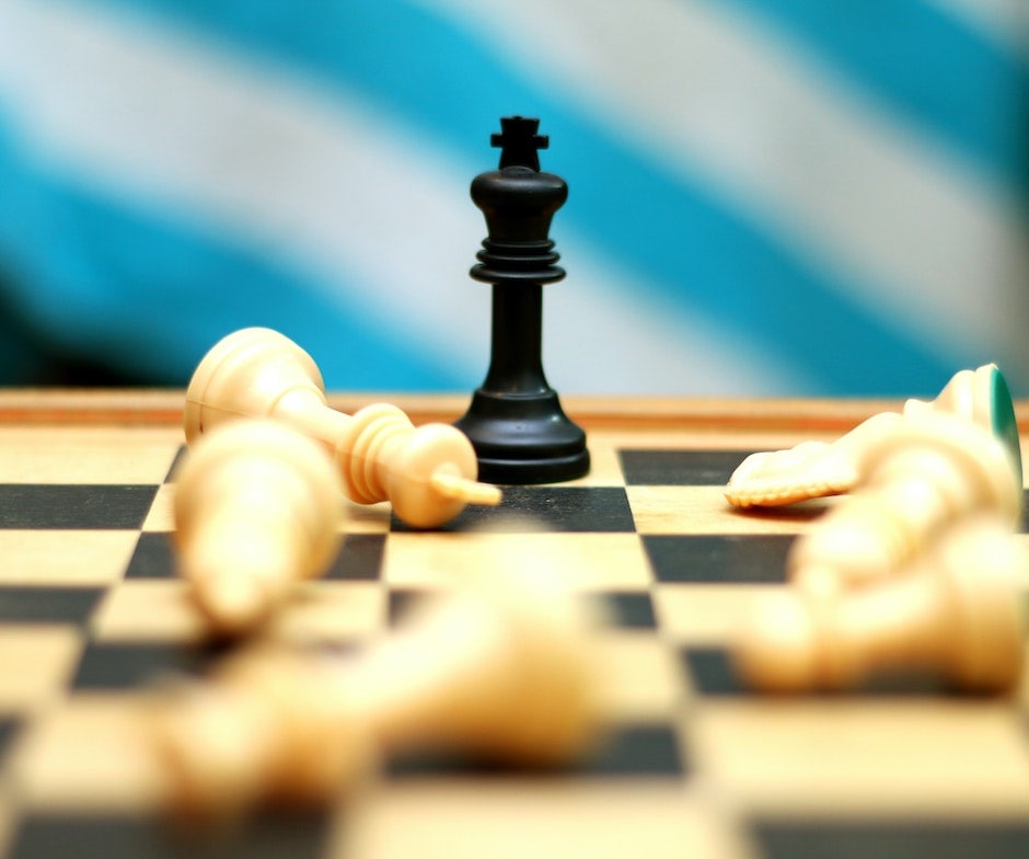 chess piece standing over knocked over pieces