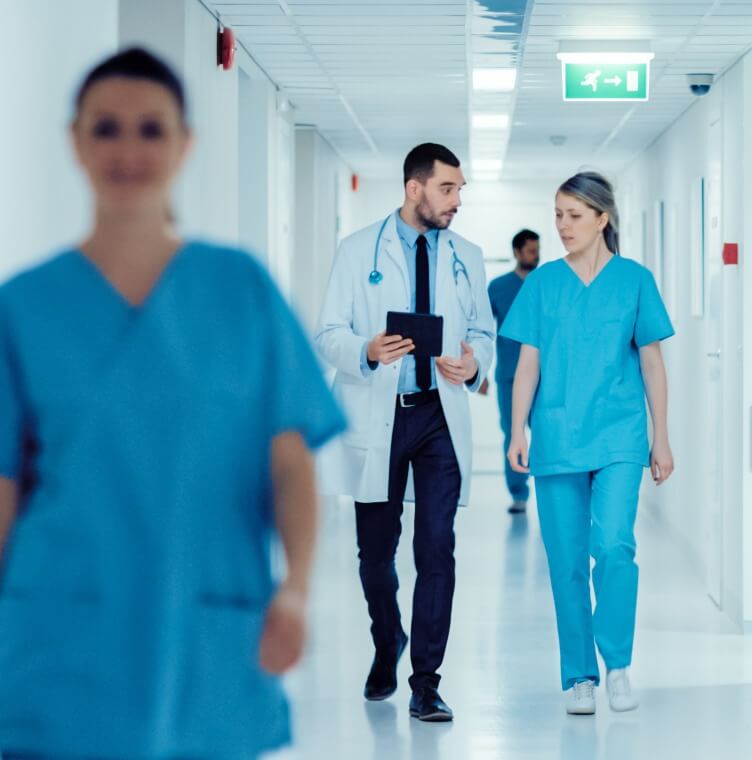 showing medical staff walking through a hospital hallway during routine clinical activity.