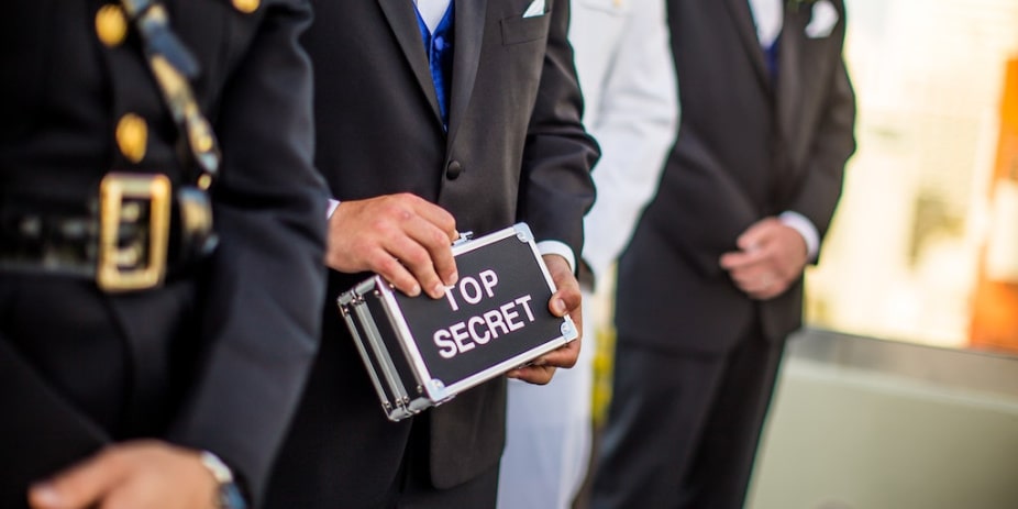 person holding case labeled 'top secret'