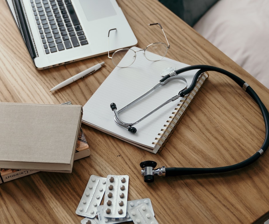 prescription, medicined and laptop on table