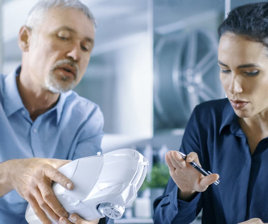 people observing mock model of car