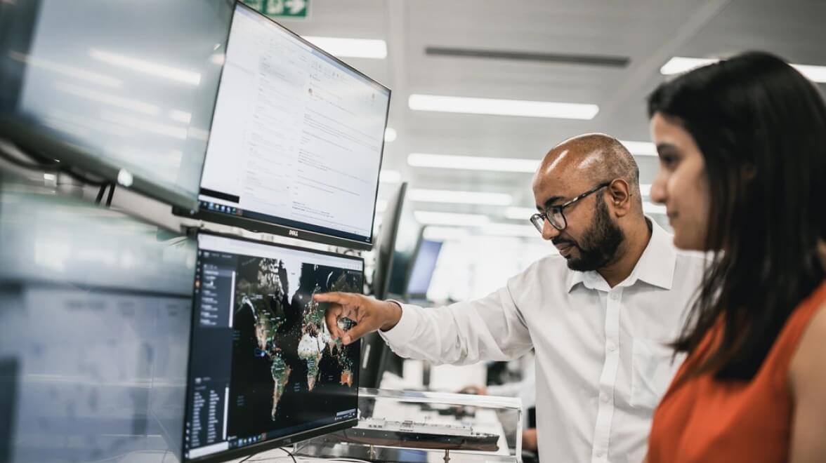 two people looking at monitor map and analyzing